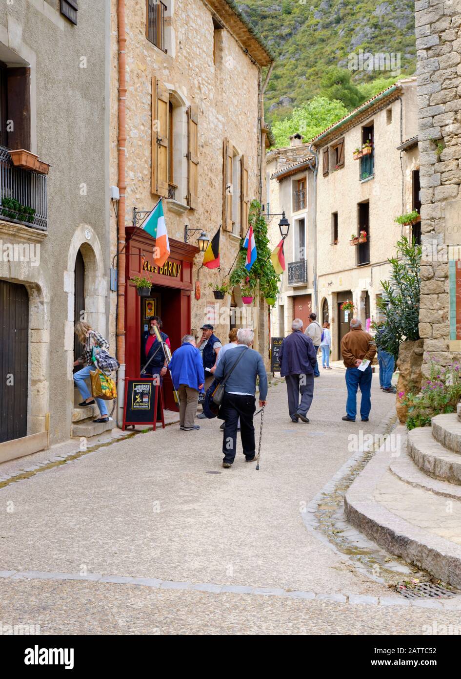 Street scene di St Guilhem le Desert, strada pedonale con vecchie case storiche su entrambi i lati. Saint-Guilhem, Francia. 3 Maggio 2019 Foto Stock