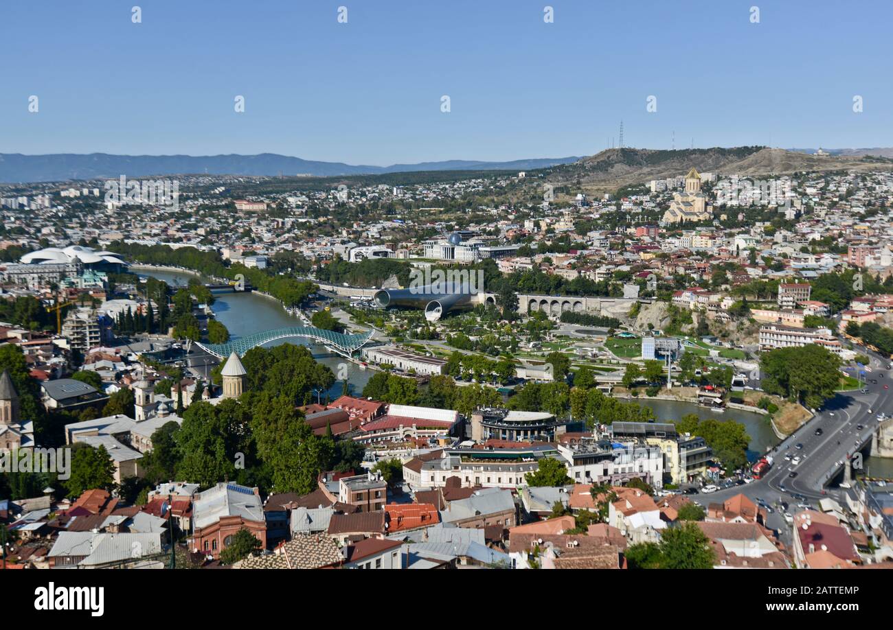 Vista panoramica di Tbilisi dalla collina di Sololaki, con il fiume Kura che attraversa il centro della città e le montagne sullo sfondo (Georgia) Foto Stock