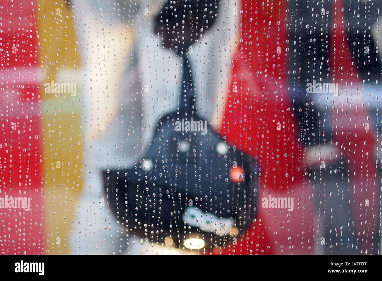 Negozio di articoli sportivi colorati (negozio di articoli sportivi) finestra manichino che tiene un casco da sci come visto attraverso una finestra molto piovosa negozio, Ottawa, Ontario, Canada. Foto Stock