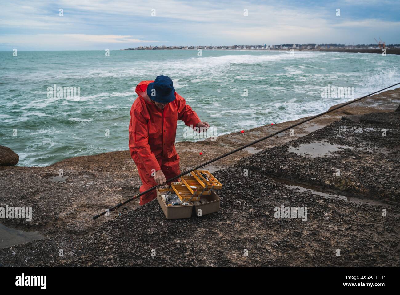 Primo piano di un pescatore che mette su esca con scatola di attrezzatura da pesca. Concetto di pesca e sport. Foto Stock