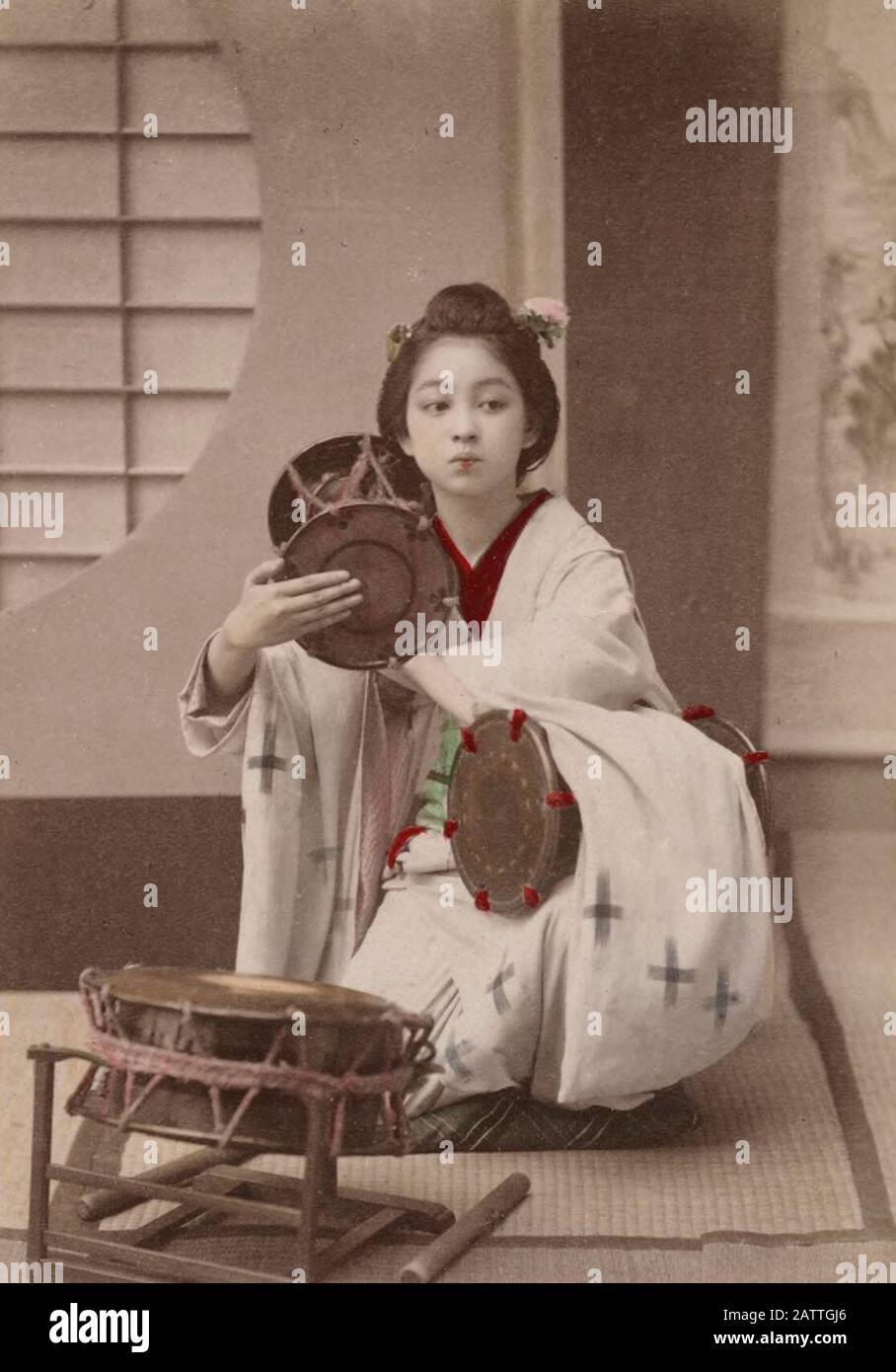 Una ragazza giapponese che batte un Tsugumi - UN Tsugumi è un piccolo tamburo tenuto, quando battuto, nella posizione mostrata. Circa 1890 Foto Stock