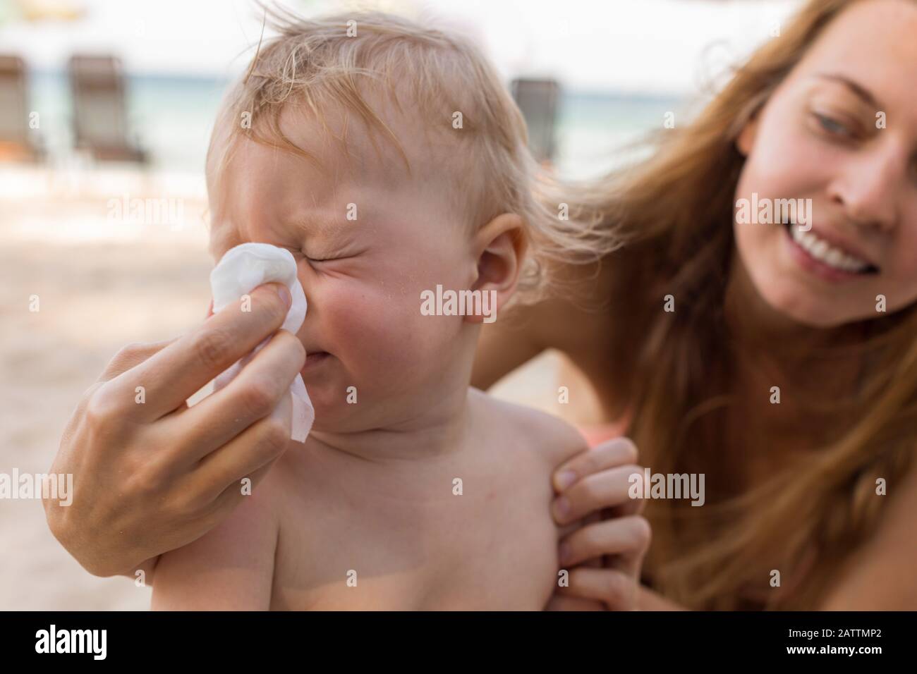 Madre che aiuta il bambino a soffiare il naso Foto Stock