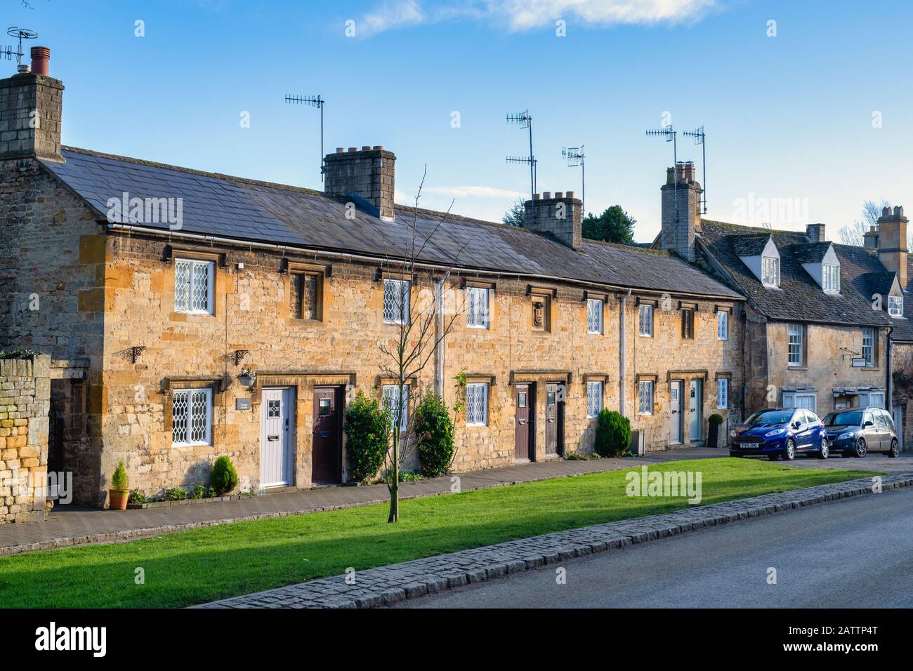 Fila di cottage collegati lungo la strada alta nel pomeriggio luce solare invernale. Chipping Campden, Cotswolds, Gloucestershire, Inghilterra Foto Stock