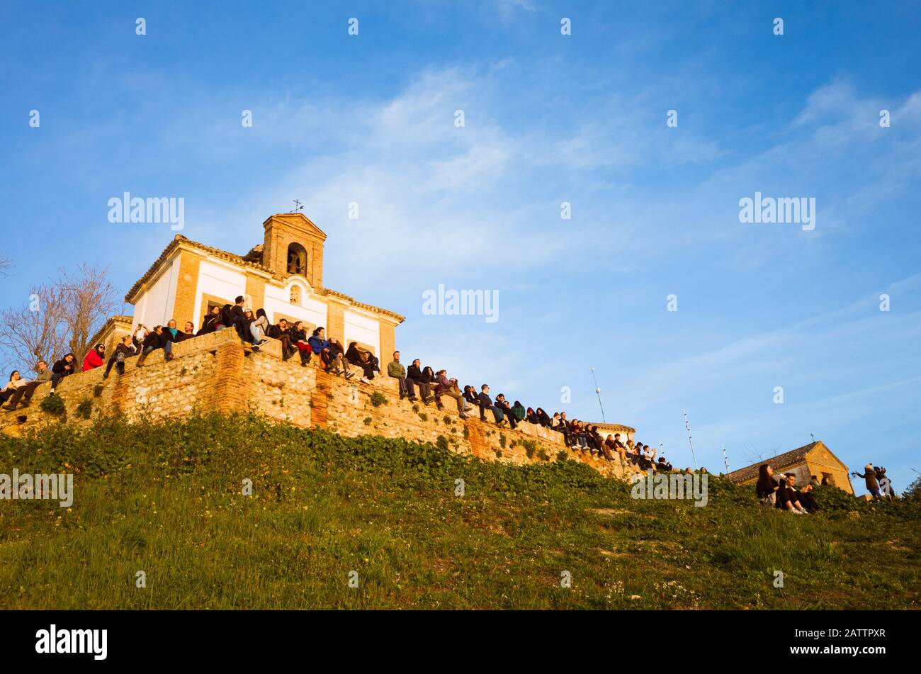Granada, Spagna - 17th gennaio 2020 : un grande gruppo di persone guarda il tramonto dal punto di vista dell'eremo di San Miguel alto. Foto Stock