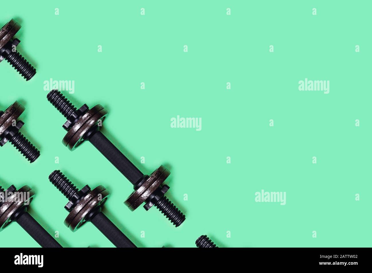 Foto sportiva. Dumbbells su sfondo verde menta. Disposizione piatta, vista dall'alto, spazio di copia. Foto Stock