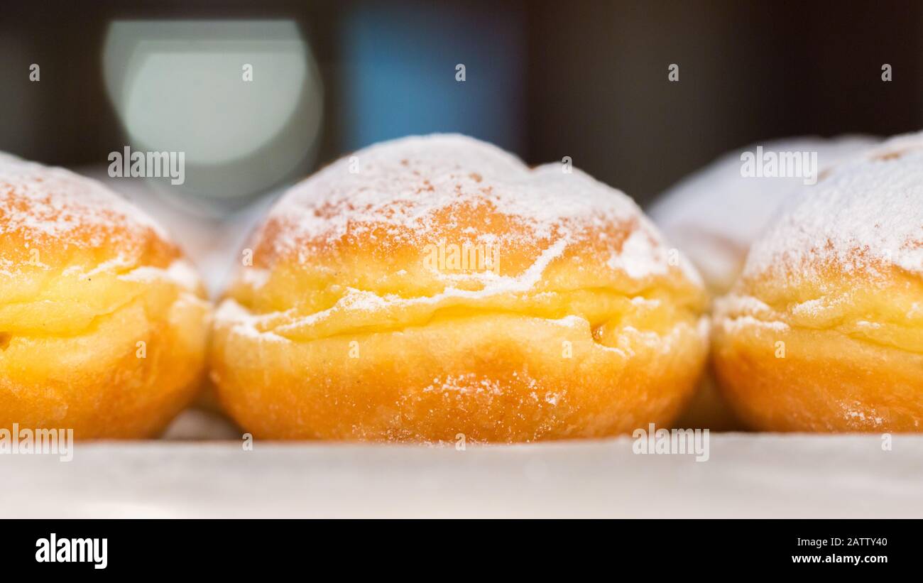 Vista laterale sul tradizionale krapfen austriaco (anche: Berliner, inglese: Ciambella). Primo piano di dolce fritto riempito di marmellata. Popolare durante il carnevale Foto Stock