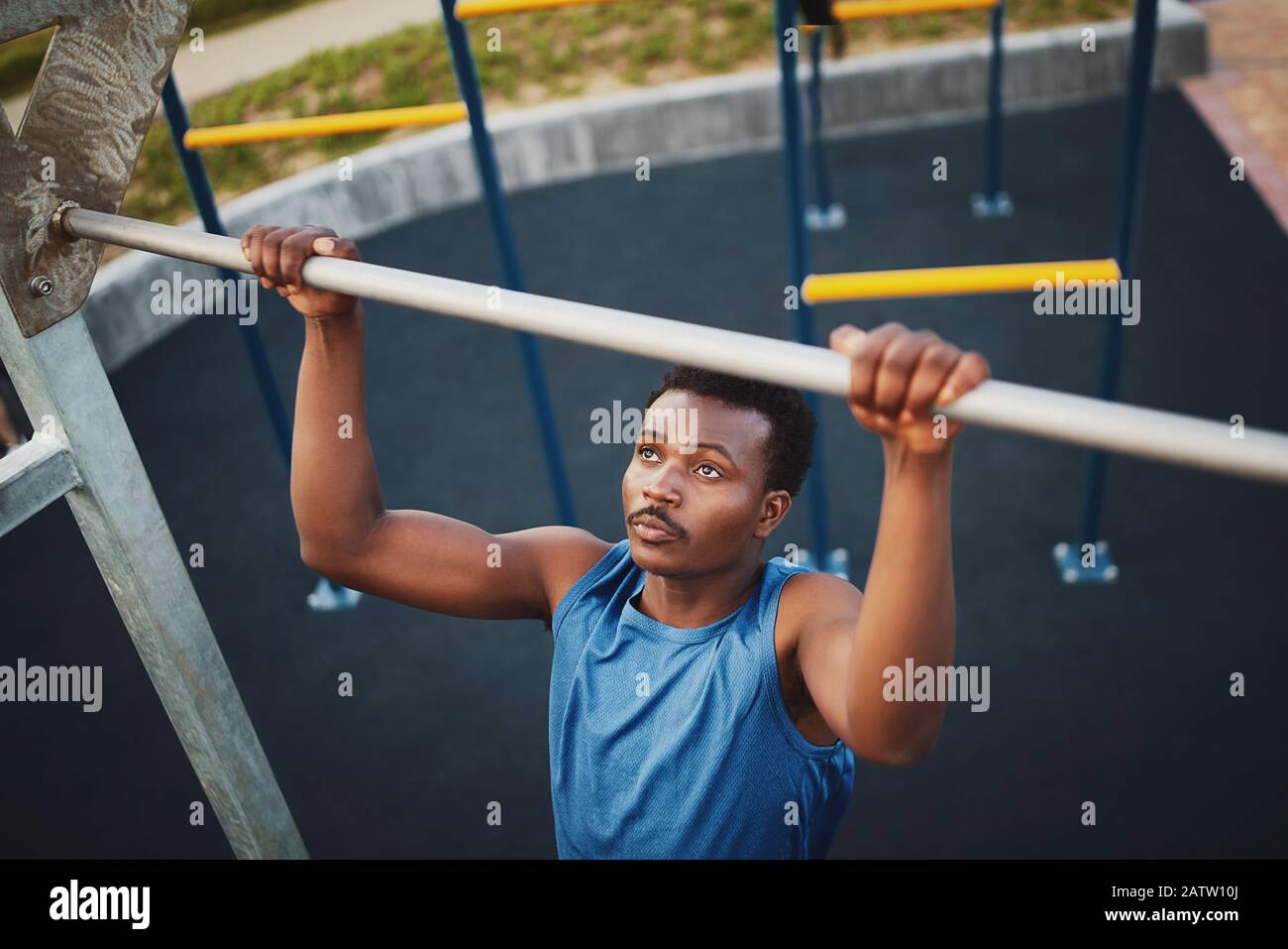 Strong FIT giovane afroamericana fare pull-up su un bar in un parco - palestra all'aperto Foto Stock