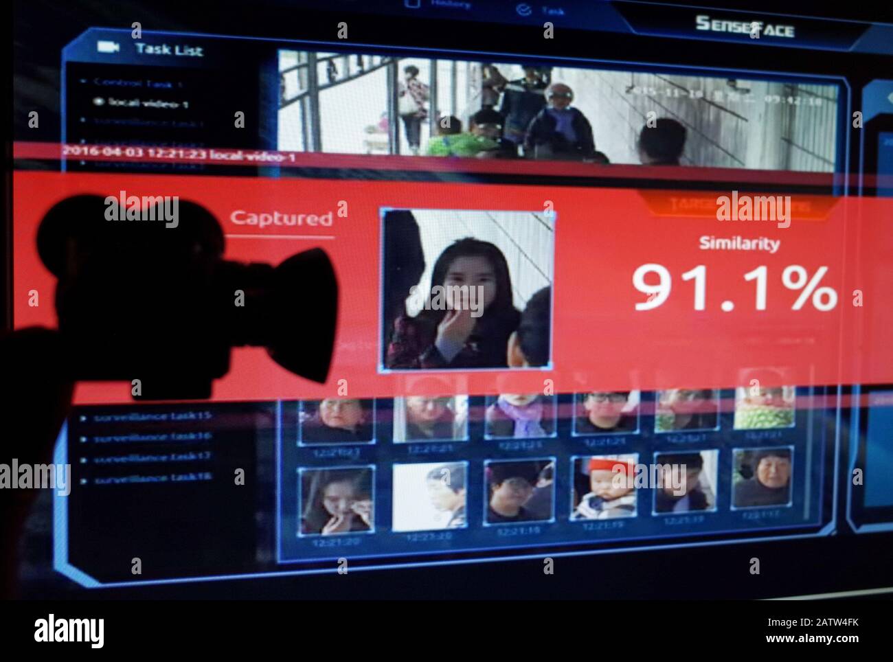 No STRETTAMENTE VENDITE AI MEDIA O EDITORI FRANCESI *** 04 febbraio 2020: Illustrazione della tecnologia cinese di riconoscimento facciale con la silhouette di una telecamera mock davanti a screen grabs presa da un video promozionale di SensetTime. SensetTime è un'azienda cinese di intelligenza artificiale il cui software SenseFace è specializzato nel riconoscimento facciale. Foto Stock