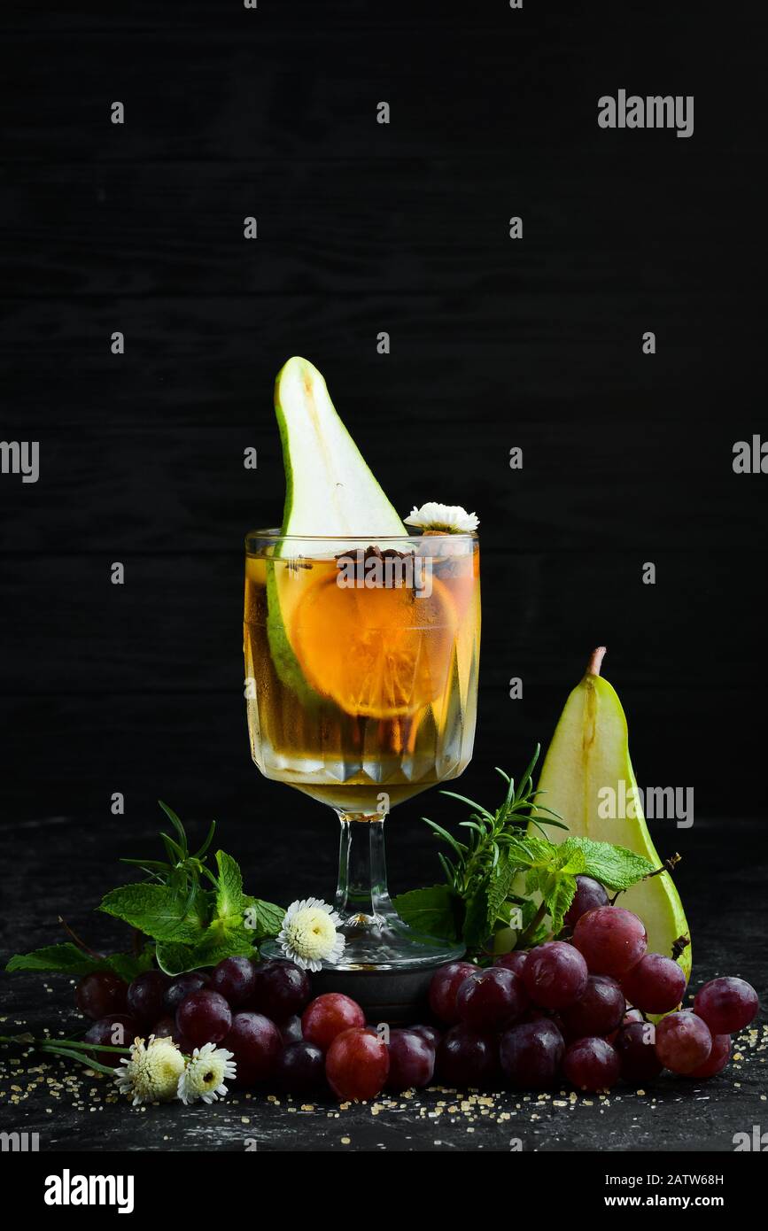 Bevande calde invernali. Vino bianco caldo con pera e cannella. Nel vetro. Vista dall'alto. Su sfondo nero. Foto Stock