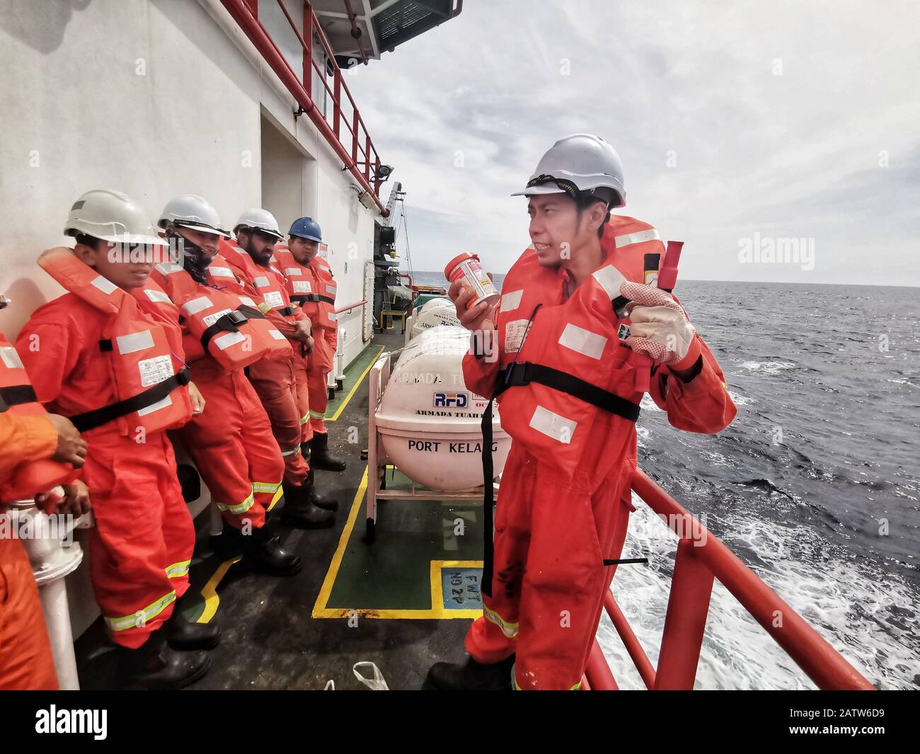 il chief officer sta eseguendo brevi briefing utilizzando le attrezzature di sicurezza e i materiali pirotecnici durante la perforazione di una nave abbandonata Foto Stock