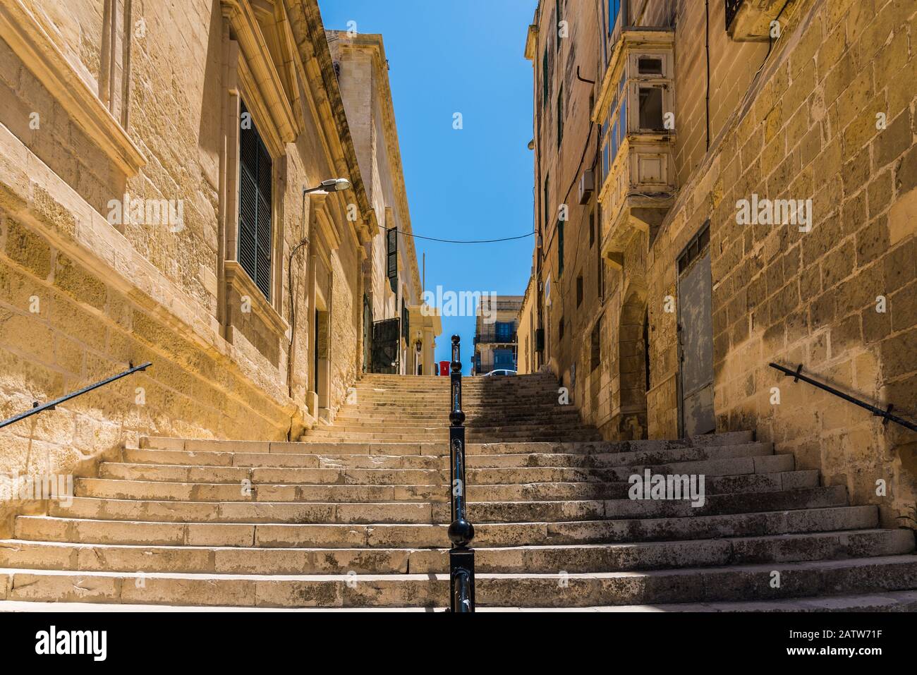 Scale tra due vecchi edifici con balconi e finestre chiuse con persiane Foto Stock