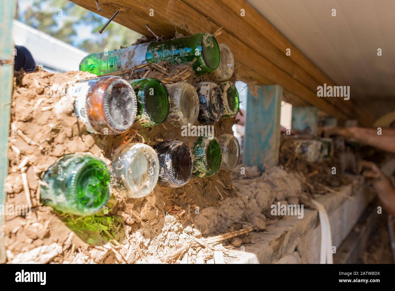 Processo di costruzione della parete della bottiglia. Eco edilizia, paglia balla casa con materiale di riciclaggio Foto Stock