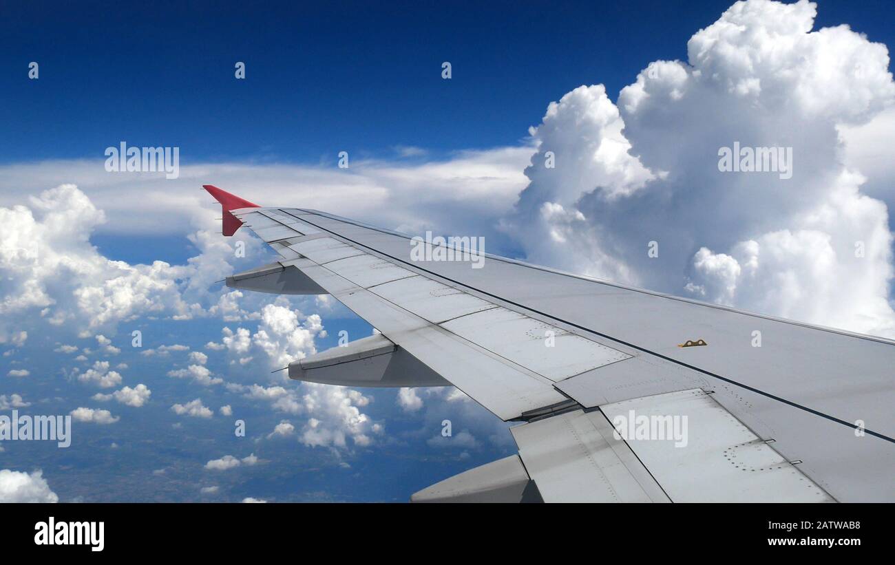 nuvole bianche e cielo blu come si vede attraverso la finestra di un aereo. concetto di viaggio e vacanza Foto Stock
