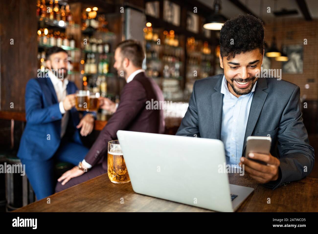 Gli uomini d'affari bevono birra dopo il lavoro. Gli uomini d'affari godono di una birra. Foto Stock