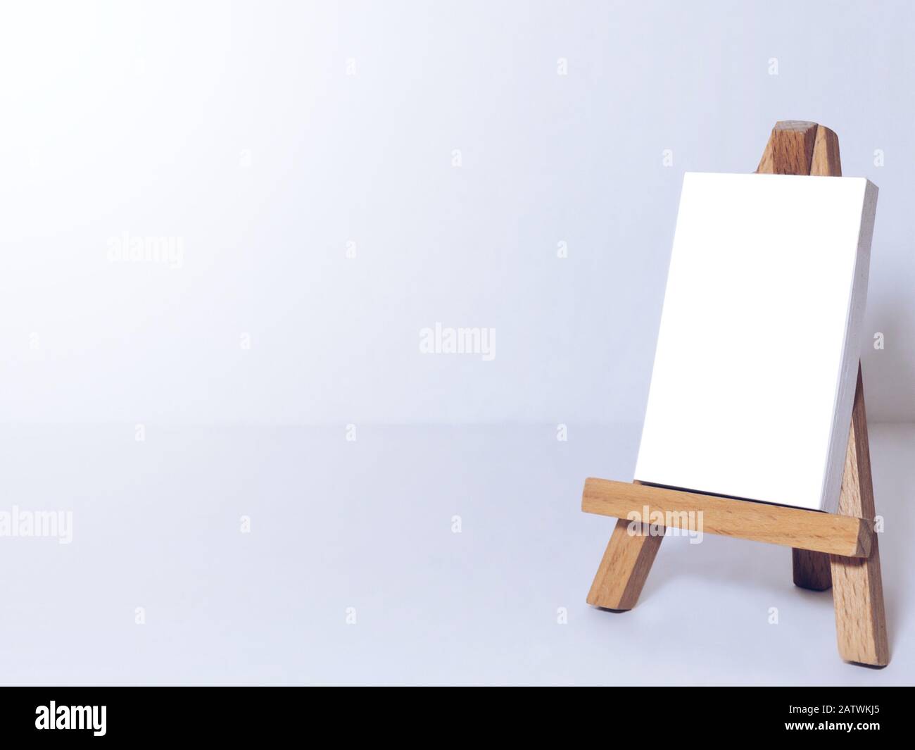 Cavalletto per artisti e tele in miniatura su sfondo bianco. Foto Stock