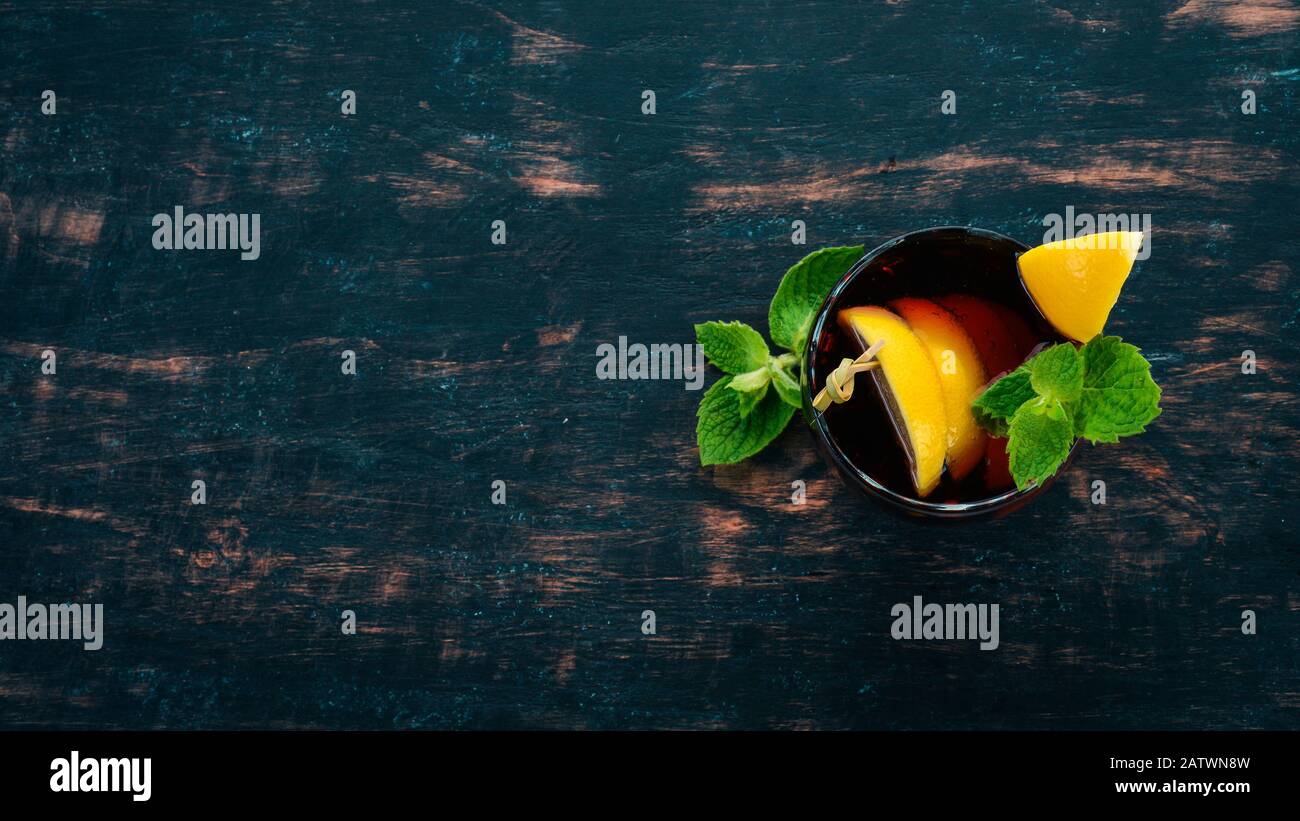 Cocktail alcolico di whisky, limone e menta. Rum-Cola. Brandy. Su uno sfondo di legno nero. Spazio libero per il testo. Foto Stock
