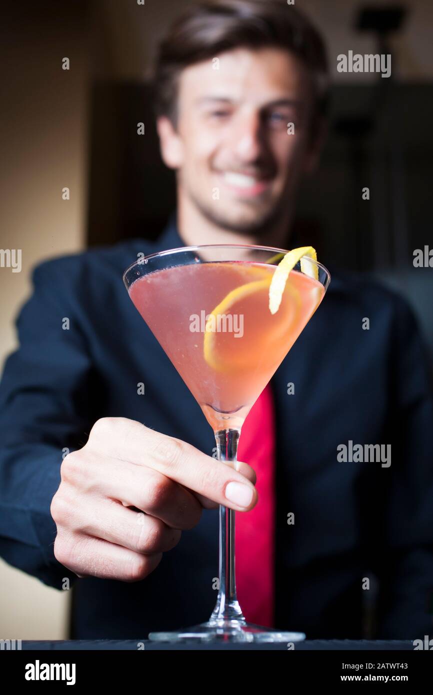 Barman che serve un cocktail. Foto Stock
