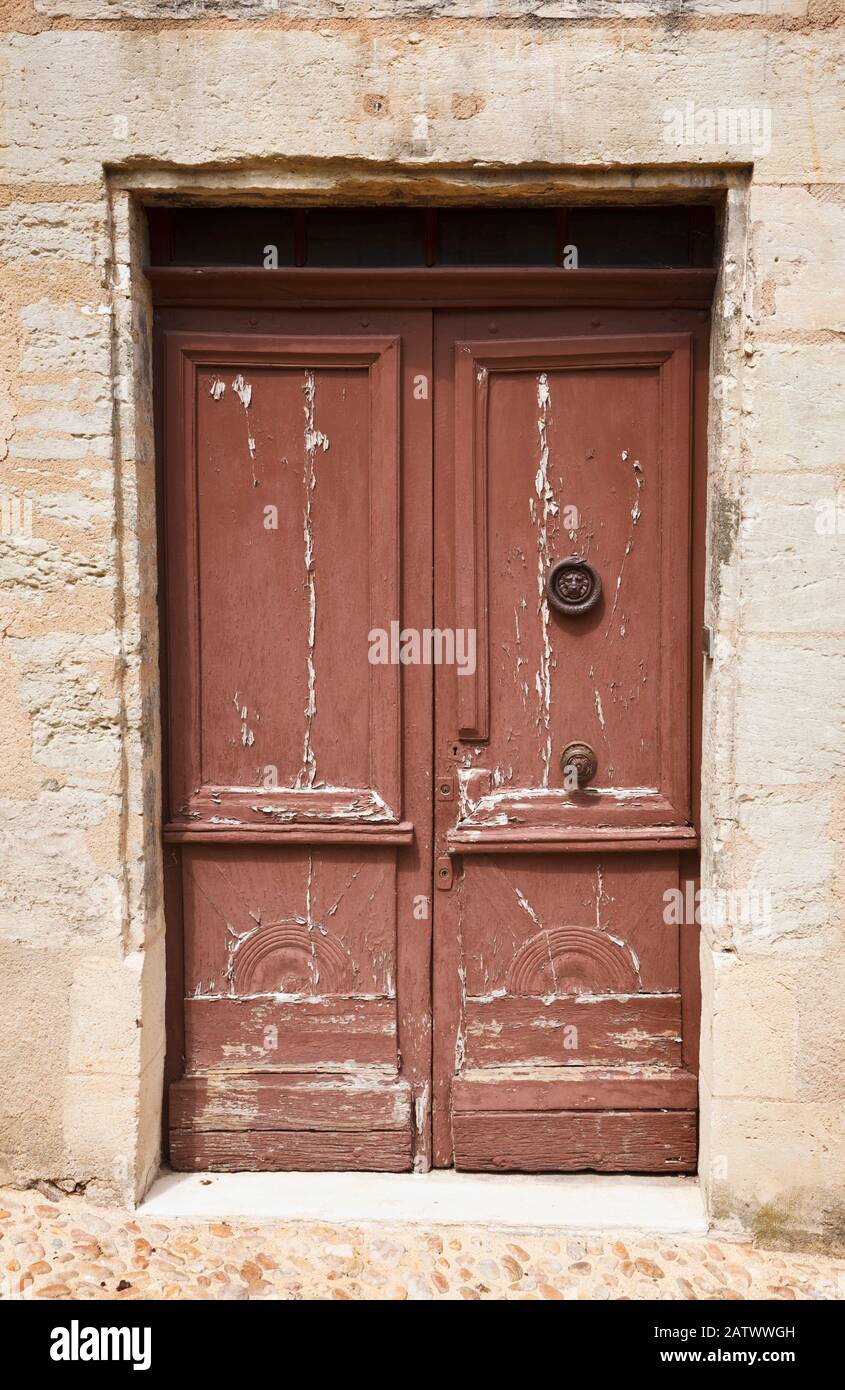 Vecchia porta di legno posta in un muro di pietra in Francia Europa Foto Stock