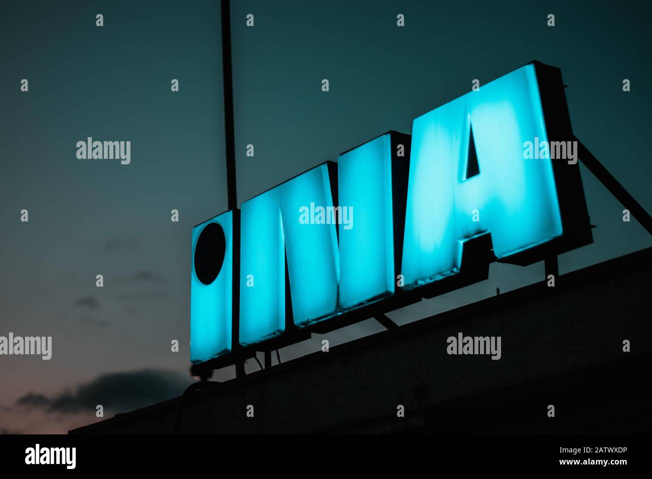 Logo INA di una compagnia petrolifera croata. Il neon luminoso di notte è di colore blu Foto Stock