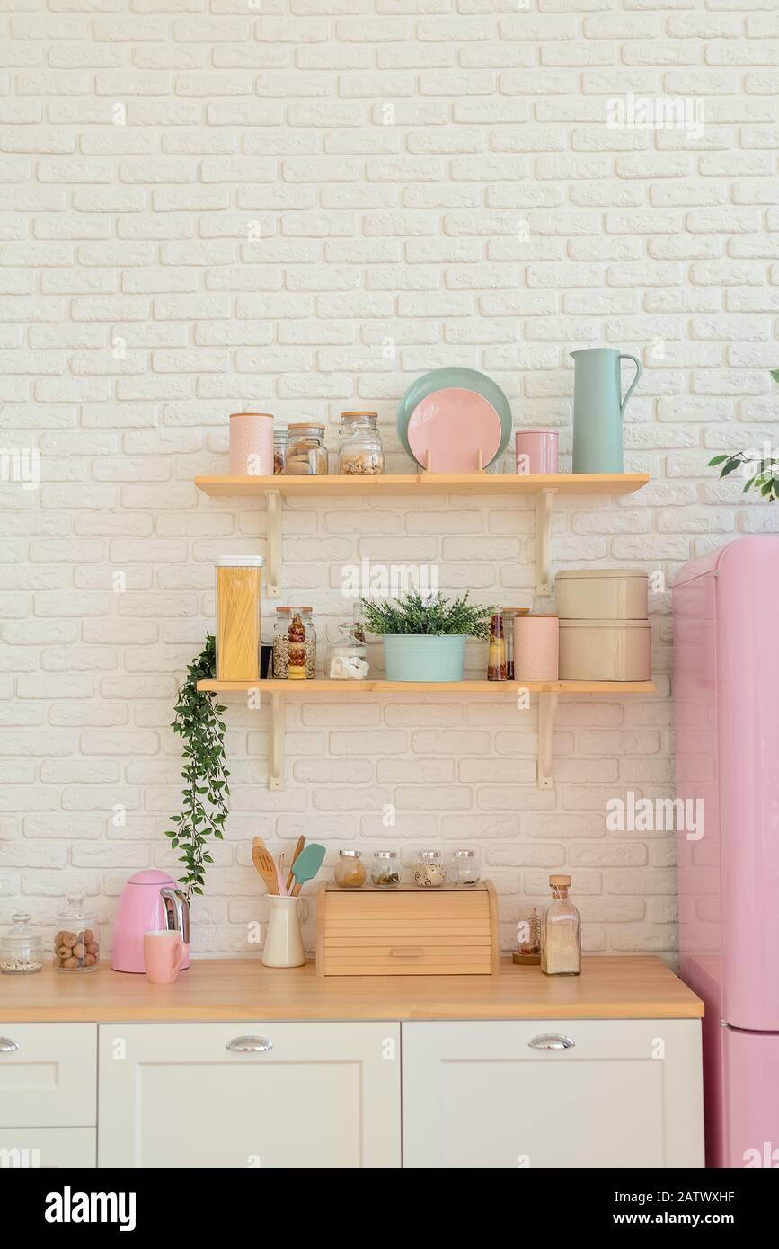 Ripiani cucina, superficie in legno e frigorifero rosa su sfondo