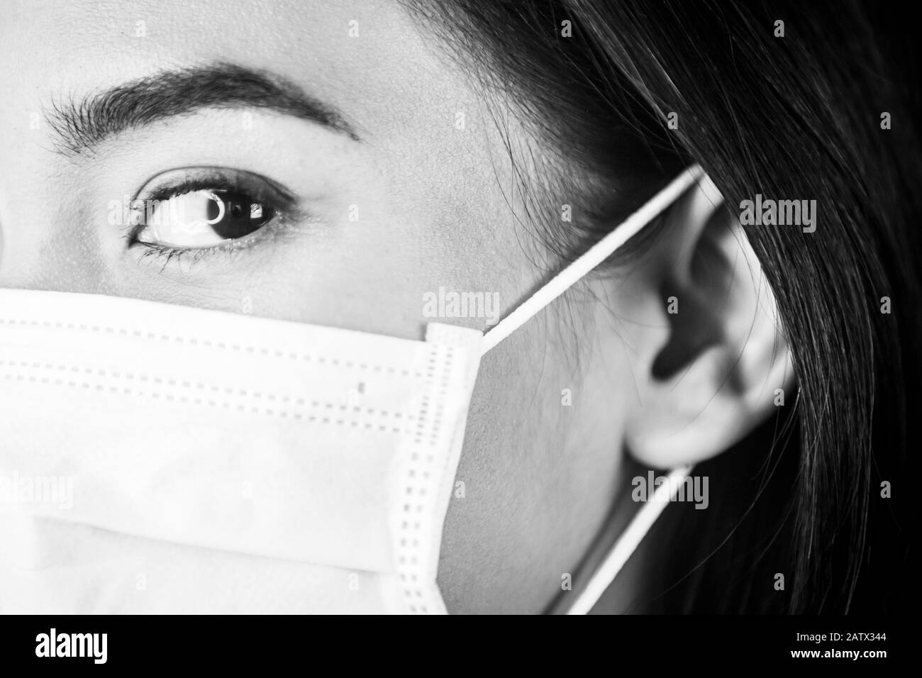 Ritratto di una donna che indossa una maschera medica per il viso per proteggere il tratto respiratorio superiore. Foto Stock