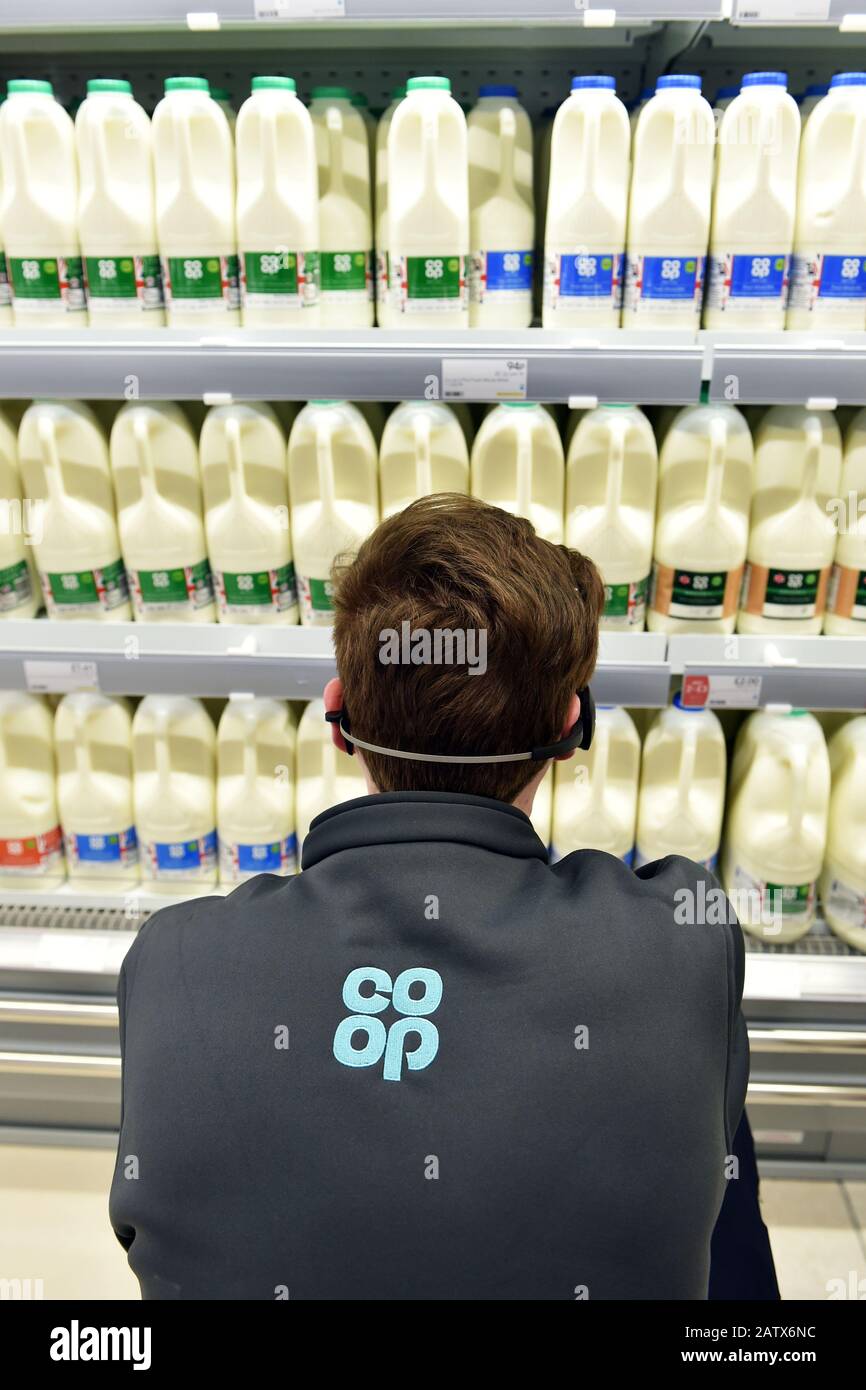 Il latte viene impilato in un supermercato Co-op frigo UK Foto Stock