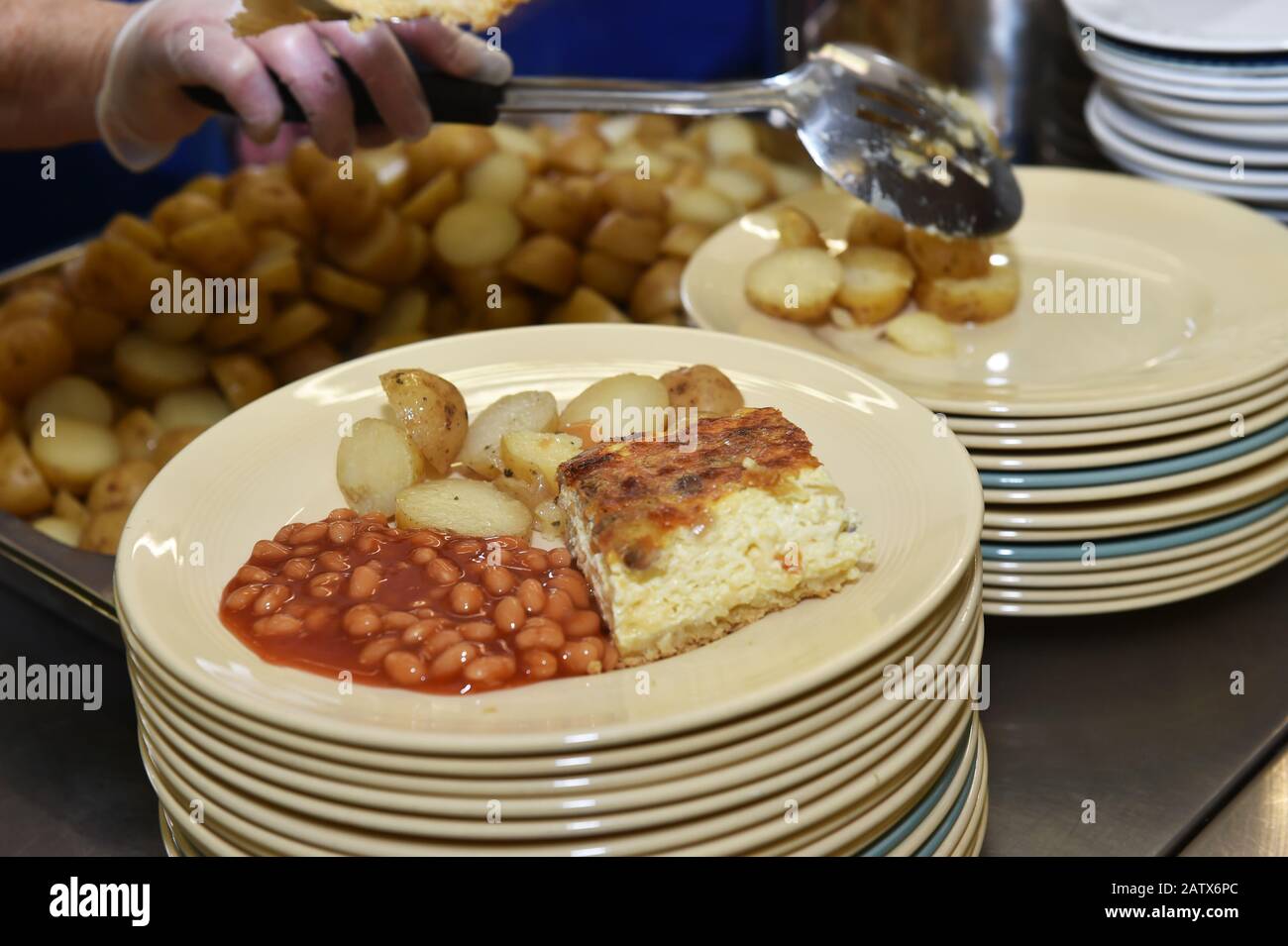 Il cibo caldo viene servito in un club per il pranzo per gli anziani Leeds UK Foto Stock