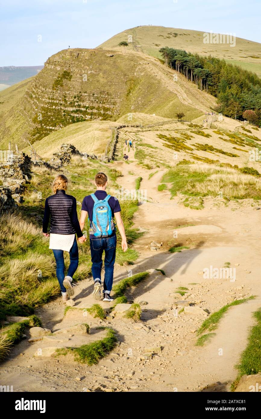 Una giovane coppia che cammina sulla Barker Bank durante l'autunno, con Back Tor e Lose Hill davanti. The Great Ridge, Derbyshire, Peak District, Inghilterra, Regno Unito Foto Stock