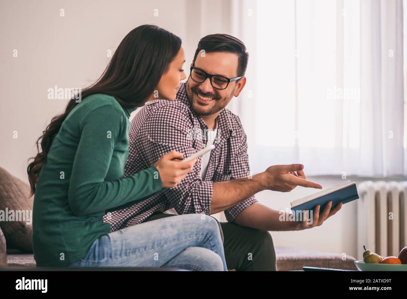 La coppia felice è seduta sul divano nella loro casa e rilassante. Foto Stock
