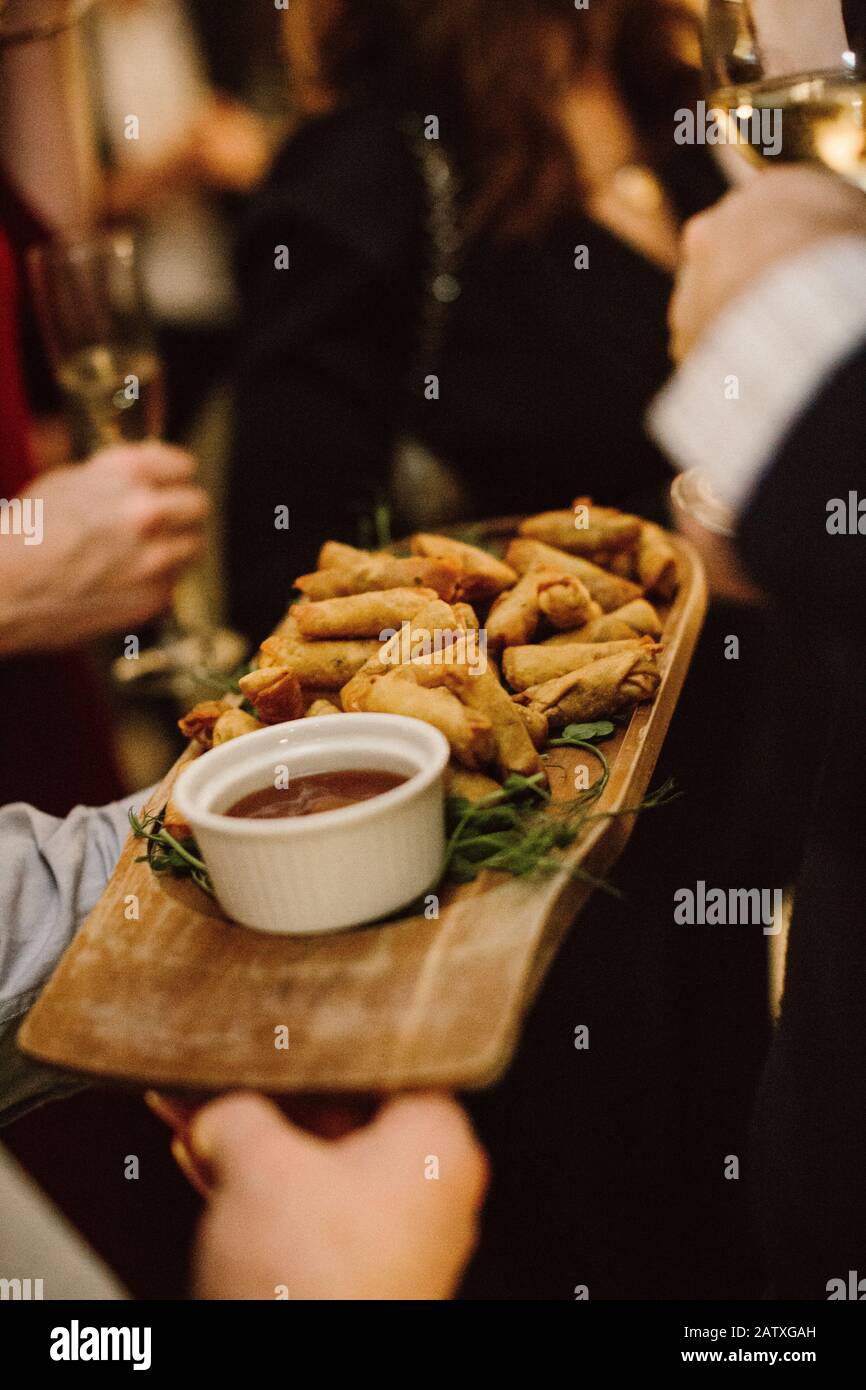 Primo piano di un piatto di cibo per le dita che viene consegnato a un evento di networking della città / festa Foto Stock