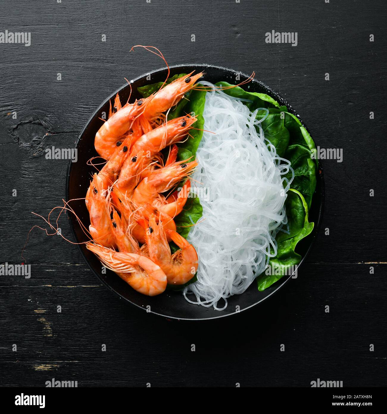 Pasta di riso con gamberi e spinaci. Cucina Asiatica Tradizionale. Vista dall'alto. Spazio libero per il testo. Foto Stock