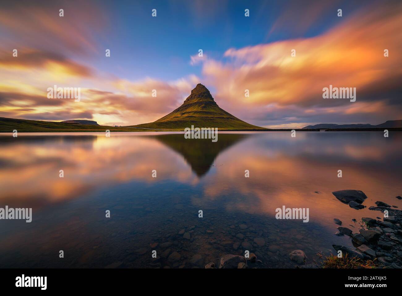 Tramonto sul monte Kirkjufell con riflessione in un vicino lago in Islanda Foto Stock