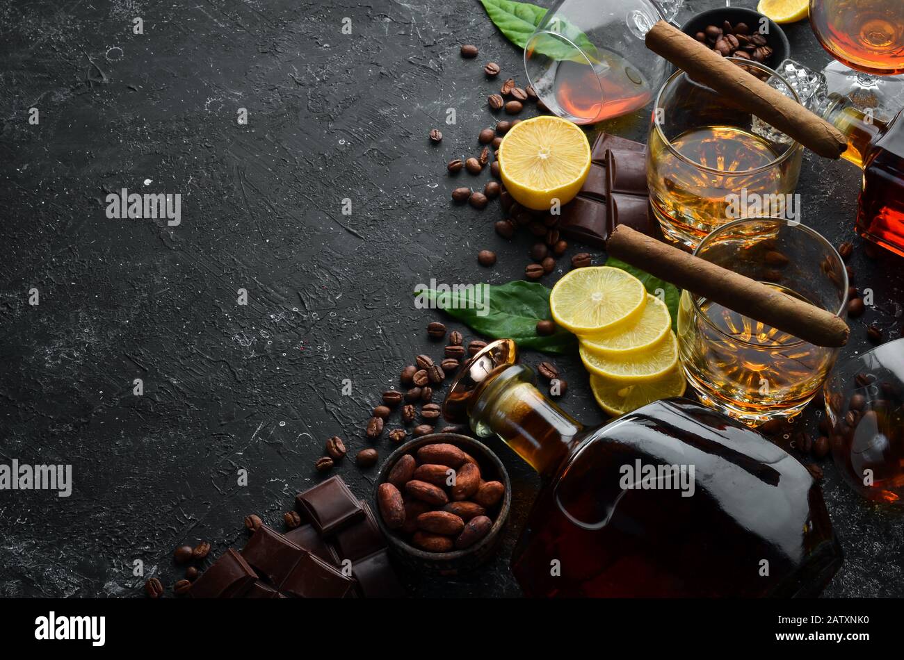 Whisky, cioccolato e sigari su un tavolo in pietra nera. Vista dall'alto. Spazio libero per il testo. Foto Stock