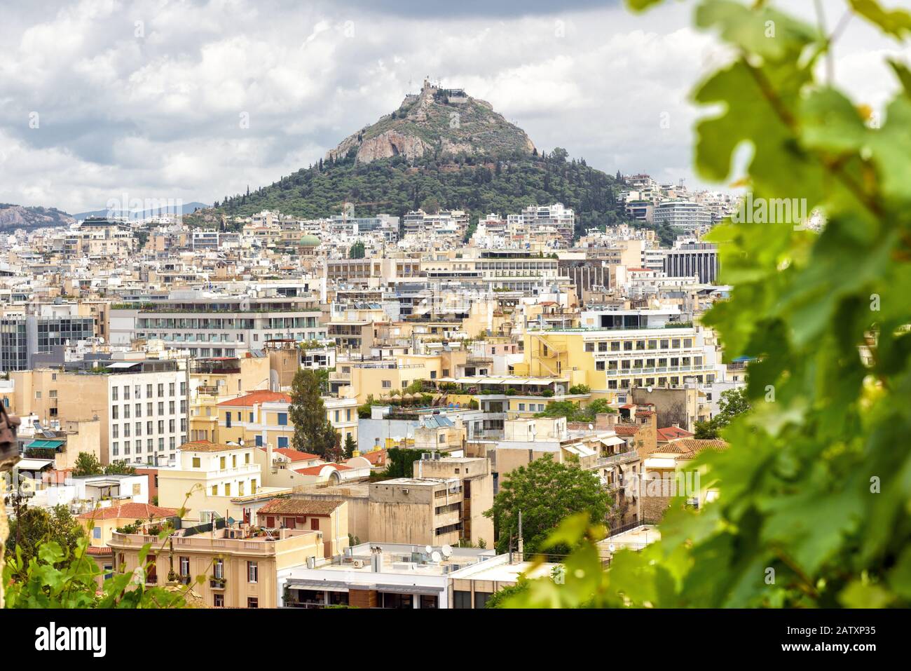 Vista panoramica di Atene e del Monte Lycabettus dal versante dell'Acropoli, Grecia. Panorama di Atene dall'alto in estate. La collina rocciosa sorge sopra la città. Foto Stock