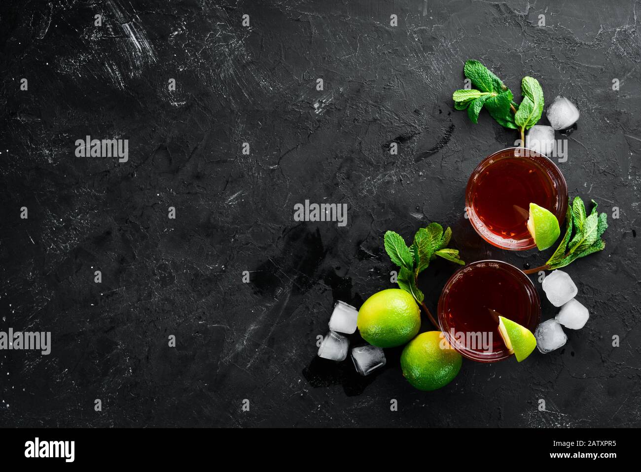 Bevande alcoliche Rum, lime e menta su sfondo di pietra nera. Vista dall'alto. Spazio libero per il testo. Foto Stock