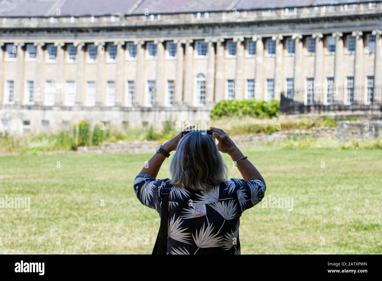 Bath, Inghilterra. Una donna è raffigurata mentre prende una fotografia del Royal Crescent a Bath, Somerset, Inghilterra, Regno Unito Foto Stock