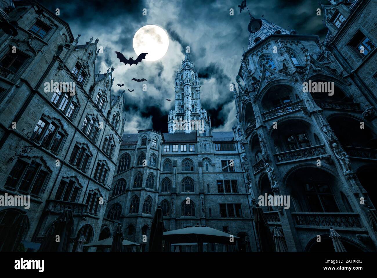 Marienplatz di notte, Monaco, Germania. Creepy mistero vista del municipio gotico scuro con pipistrelli. Vecchio castello spettrale o palazzo in luna piena. Spaventoso buio Foto Stock