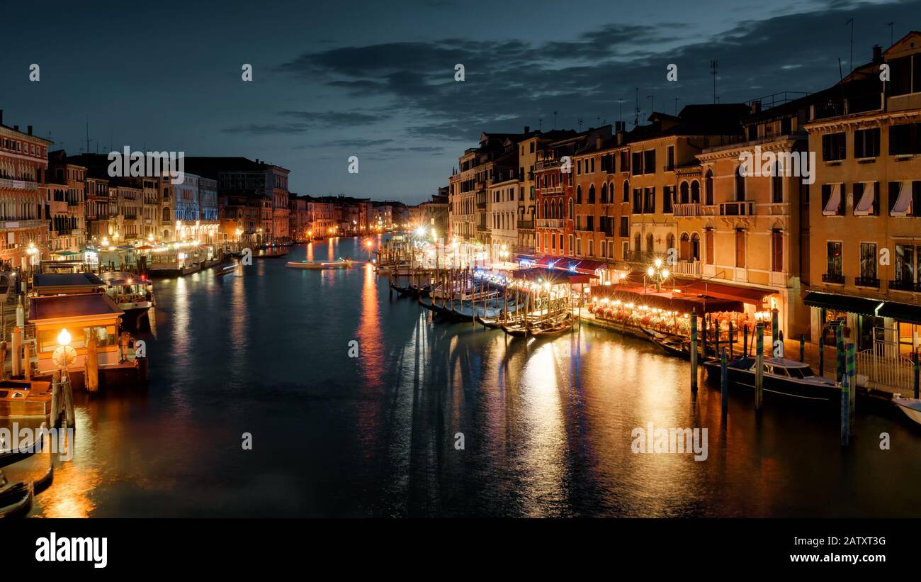 Canal Grande di notte, Venezia, Italia. E' una delle attrazioni turistiche più conosciute di Venezia. Vista panoramica della Venezia illuminata al tramonto. Vita notturna a Venezia. Foto Stock