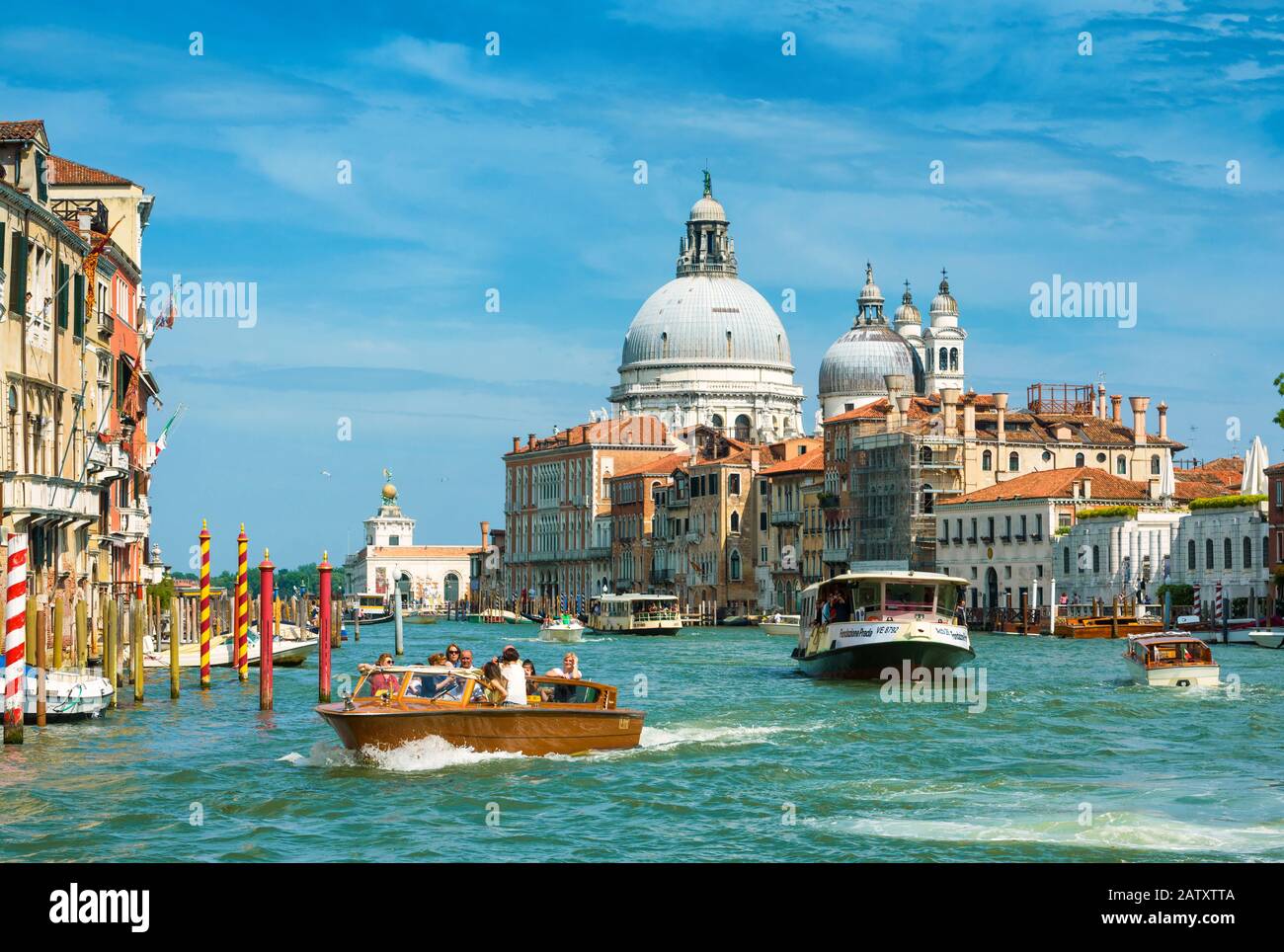 Venezia, Italia - 19 maggio 2017: I taxi d'acqua e il vaporetto con i turisti navigano lungo il Canal Grande di Venezia. Le barche a motore sono il trasporto principale Foto Stock