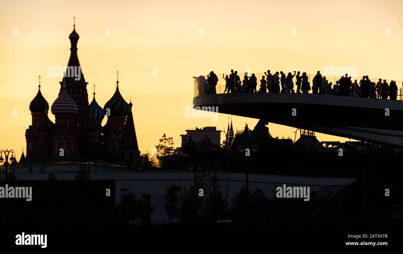 Mosca al tramonto, Russia. Ponte galleggiante con vista sulla Cattedrale di San Basilio`s. Il Parco Zaryadye è un'attrazione turistica di Mosca. La gente visita la Mosca l Foto Stock