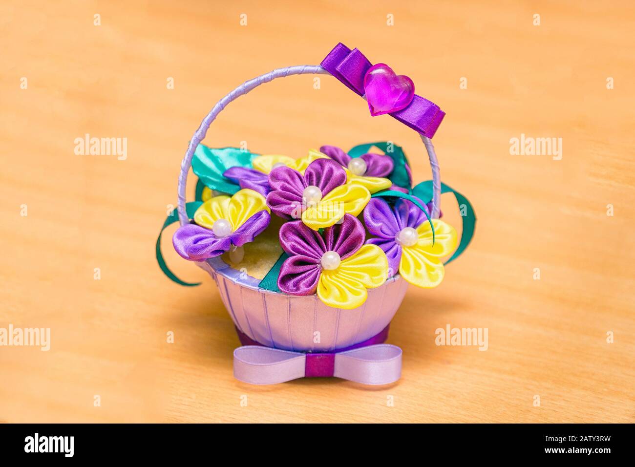 Violetti artificiali in un piccolo vaso su sfondo o tavolo di legno Foto Stock