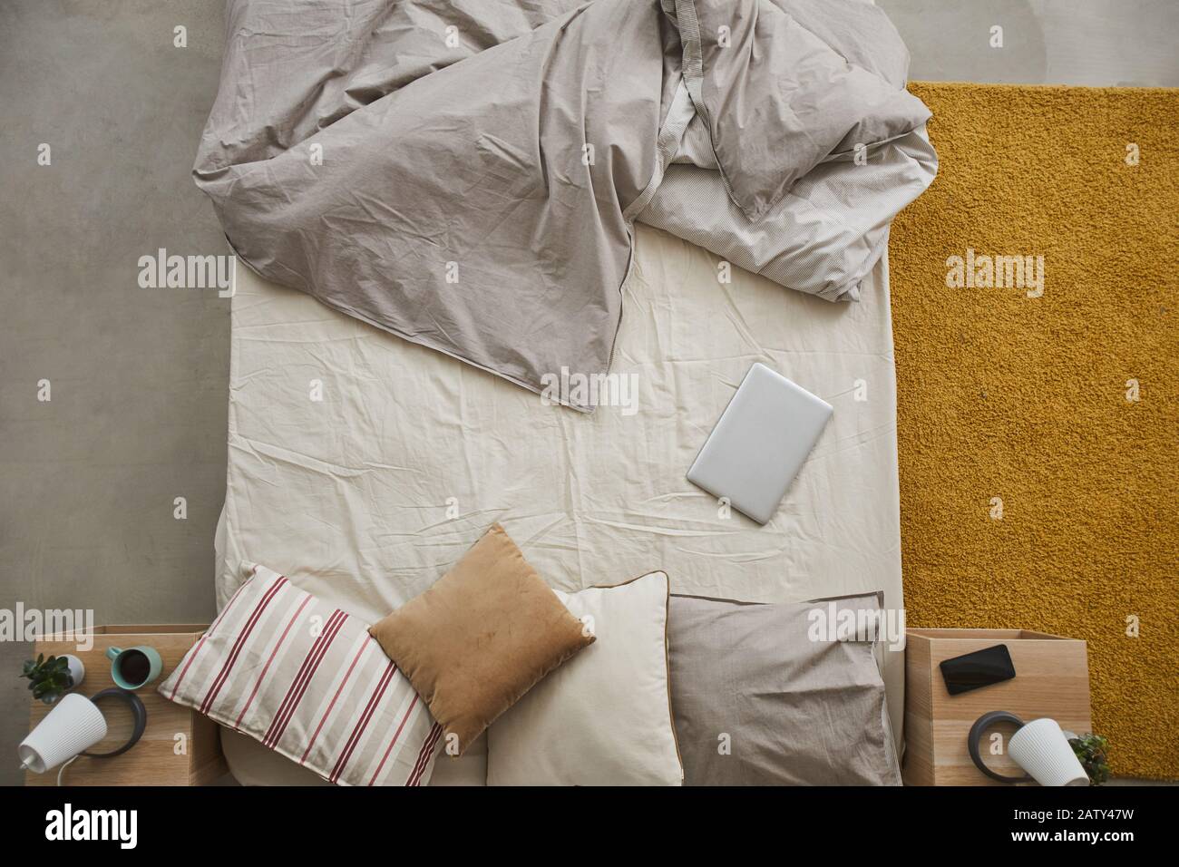 Vista ad alto angolo del letto vuoto con tablet digitale nella camera da letto di casa Foto Stock