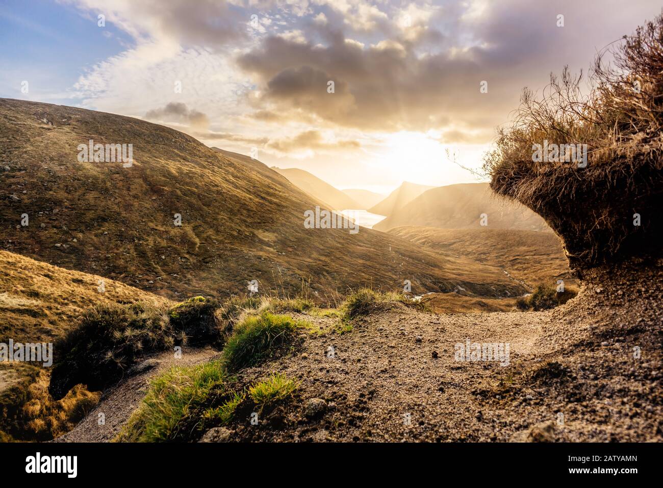 Fiume e bacino idrico nella splendida valle con il tramonto drammatico in Monti Del Lutto. La più drammatica e la più alta gamma dell'Irlanda del Nord Foto Stock