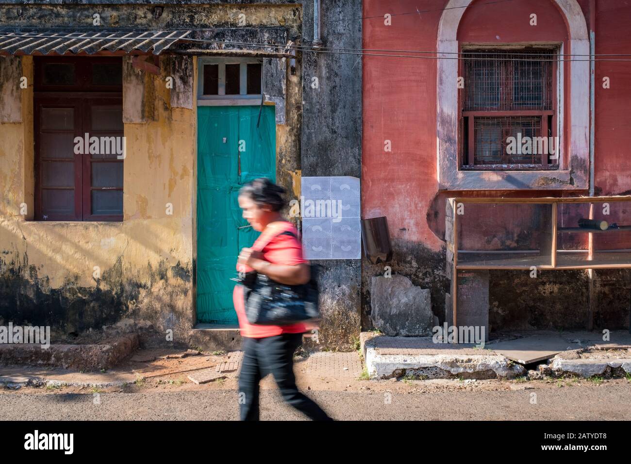 Fontainhas, Panaji, Goa, India - 27 febbraio 2018: Irriconoscibile donna indiana che cammina di fronte a case colorate nel famoso quartiere di Fontainh Foto Stock