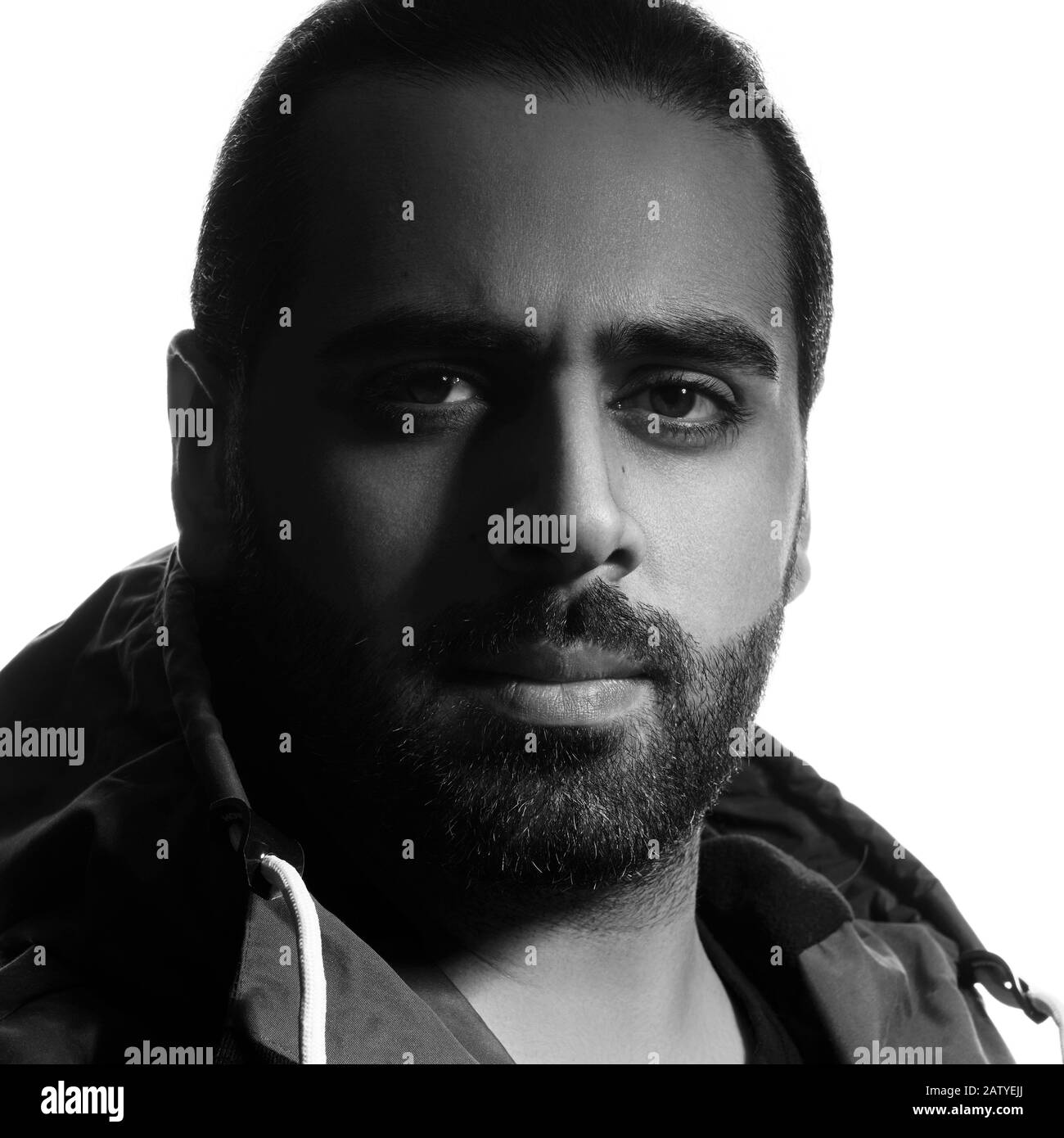 Colpo di testa bianco e nero di un serio uomo medio orientale su sfondo bianco Foto Stock