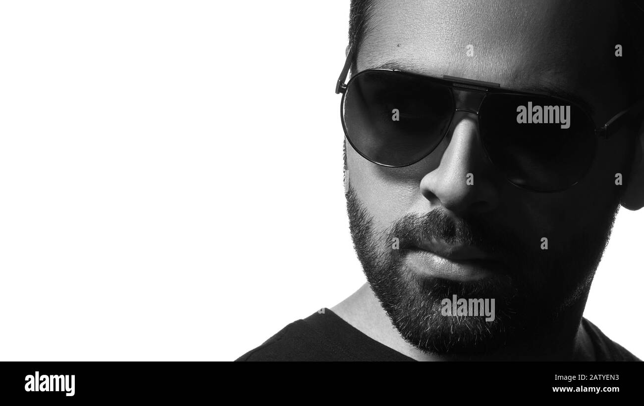 Nero e bianco colpo testa di uomo arabo indossando occhiali da sole su sfondo bianco con spazio copia Foto Stock