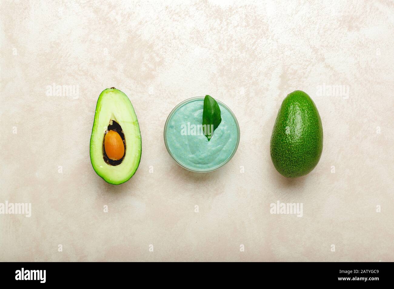 Maschera viso avocado in vaso di vetro con foglie e avocado. Maschera nutriente fatta in casa di avocado purè. Ricetta fai da te per cosmetici Fatti In Casa, cura della pelle Foto Stock