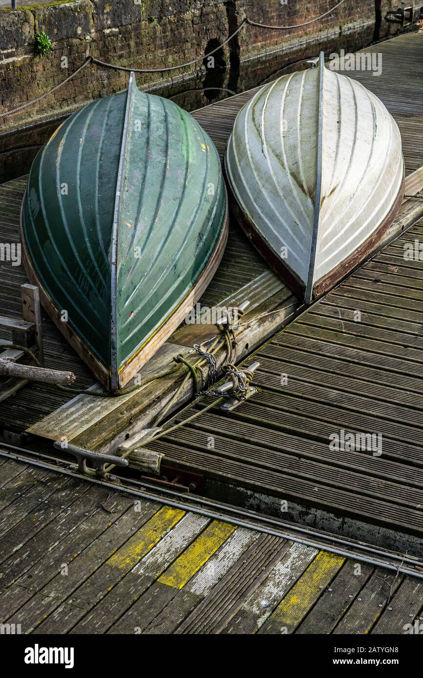 Due vecchie barche di legno rovesciate su un molo di legno Foto Stock