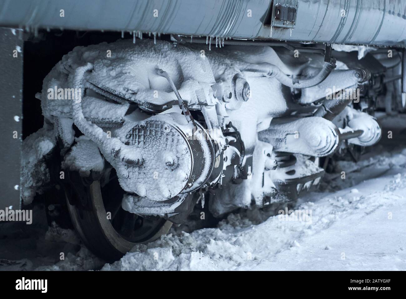 carrello coperto da ghiaccio e neve di un trasporto ferroviario di passeggeri su rotaie durante il funzionamento in inverno Foto Stock