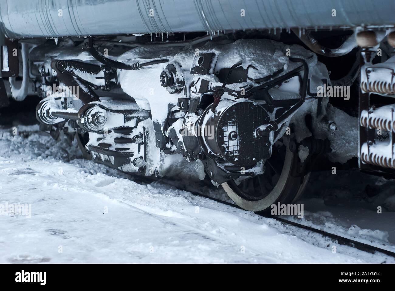 carrello coperto da ghiaccio e neve di un trasporto ferroviario di passeggeri su rotaie durante il funzionamento in inverno Foto Stock